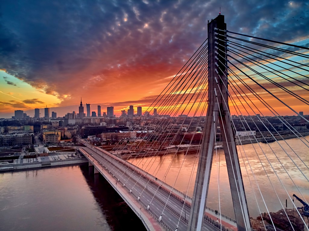 Beautiful panoramic aerial drone sunset view to Warsaw city center with skyscrapers and Swietokrzyski Bridge (En_ Holy Cross Bridge) - is a cable-stayed bridge over the Vistula river in Warsaw, Poland